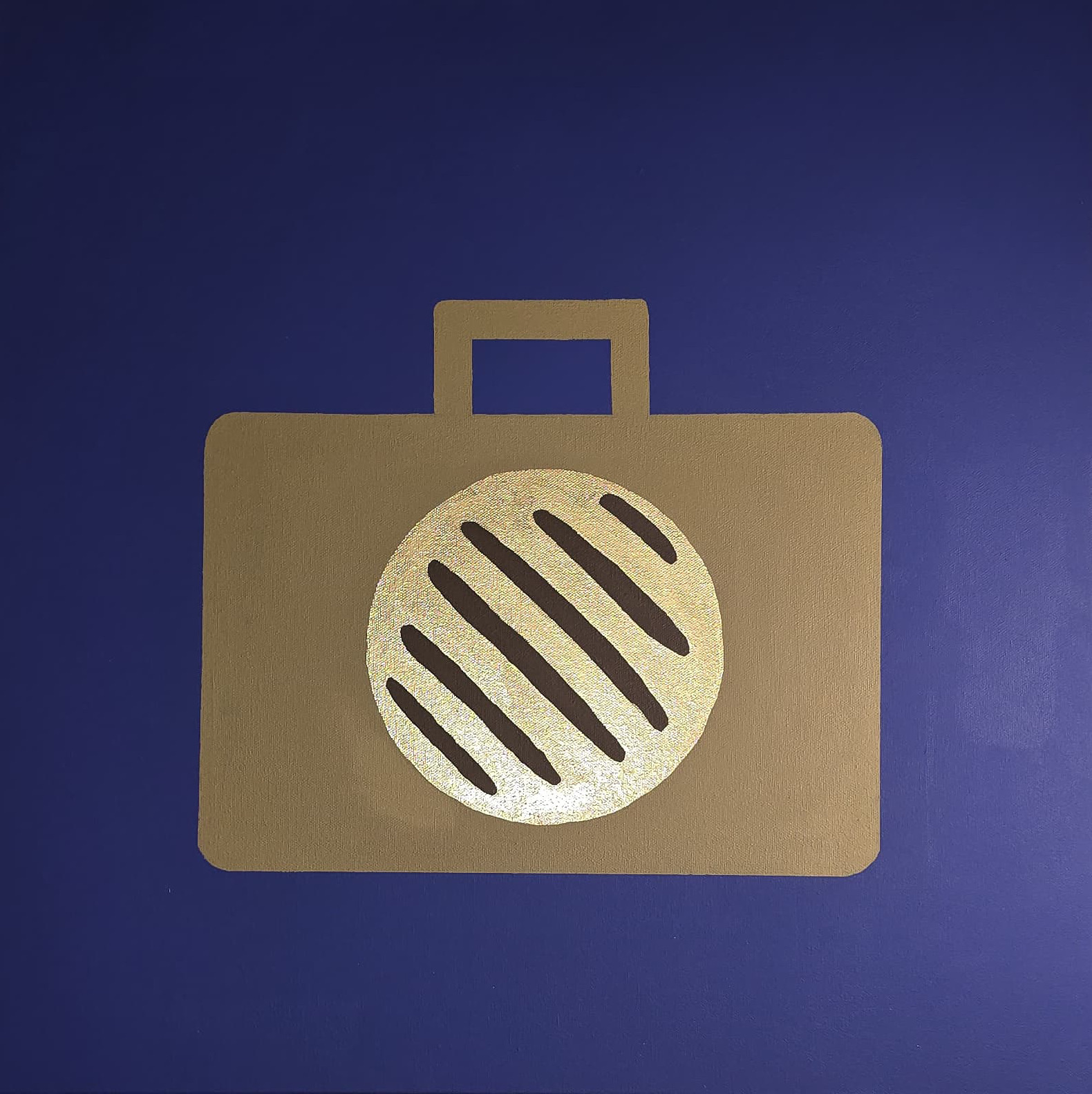 A flat gold suitcase, seen square on, centred on a deep indigo ground. Inside it a disc of gold leaf carries dark diagonal bars across its face, like the griddle marks on a flatbread.