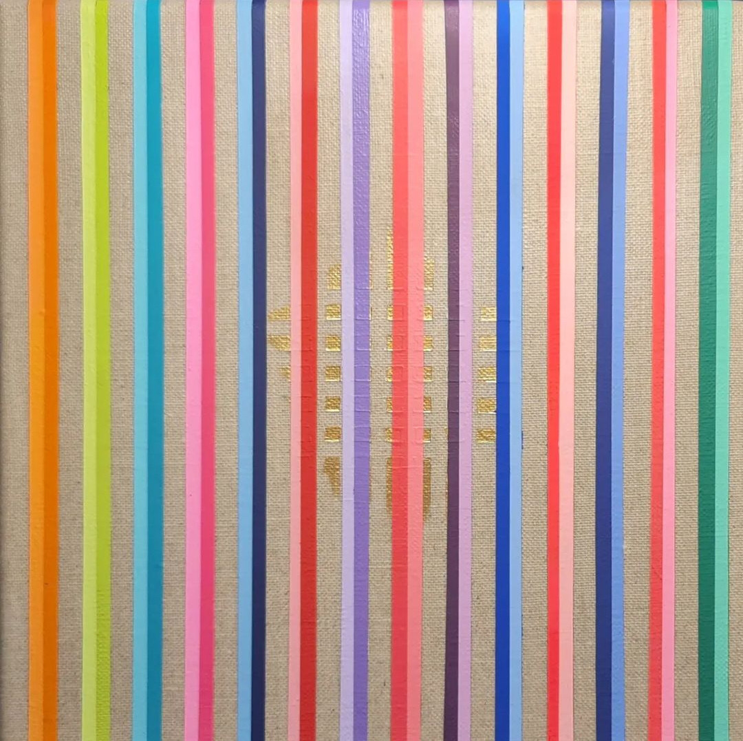 Bright vertical stripes — orange, lime, cyan, pink, red, lilac, blue, green — on unprimed linen, with small marks of gold leaf clustered at the centre.